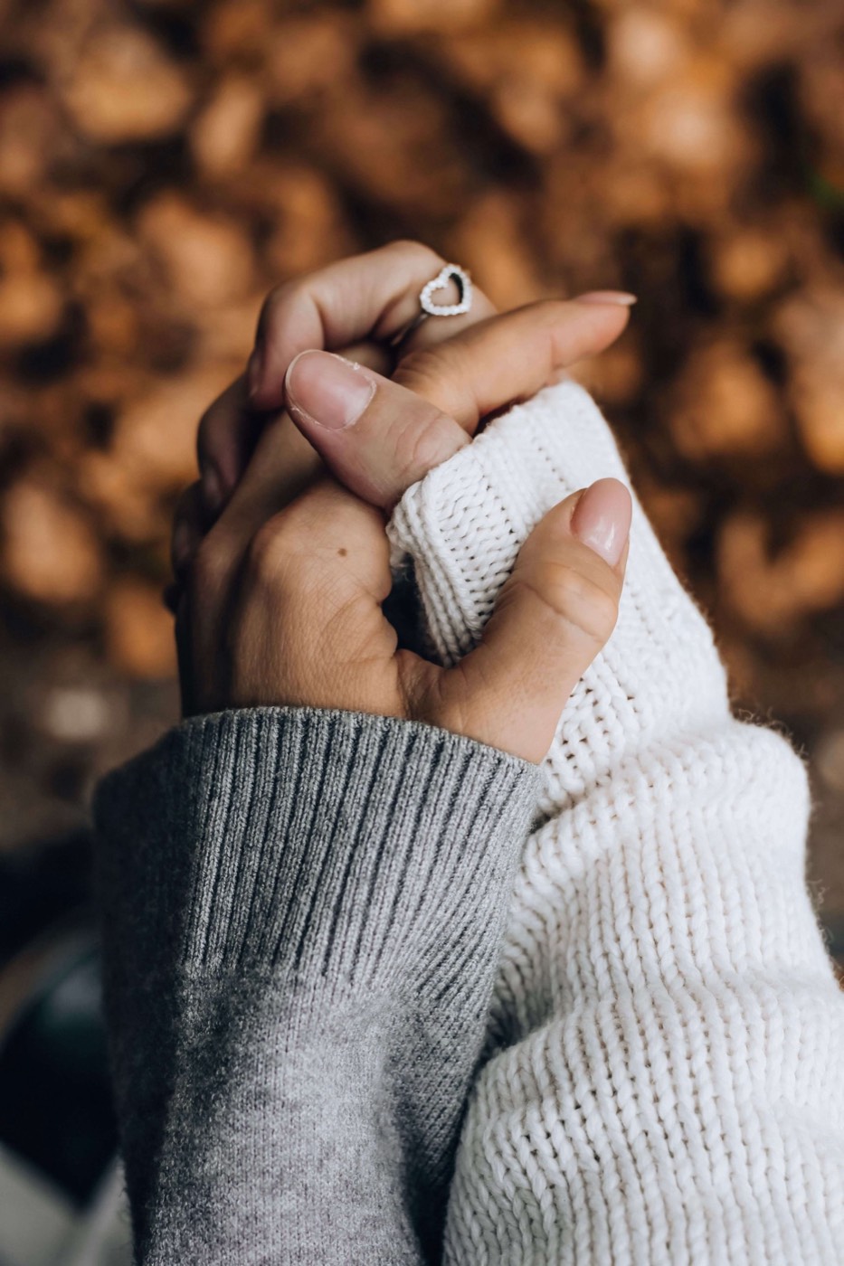 Two hands in knitted sleeves holding each other